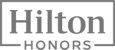 The image shows the logo for Hilton Honors, with "Hilton" in a large font and "HONORS" in a smaller font below it within a rectangular frame.